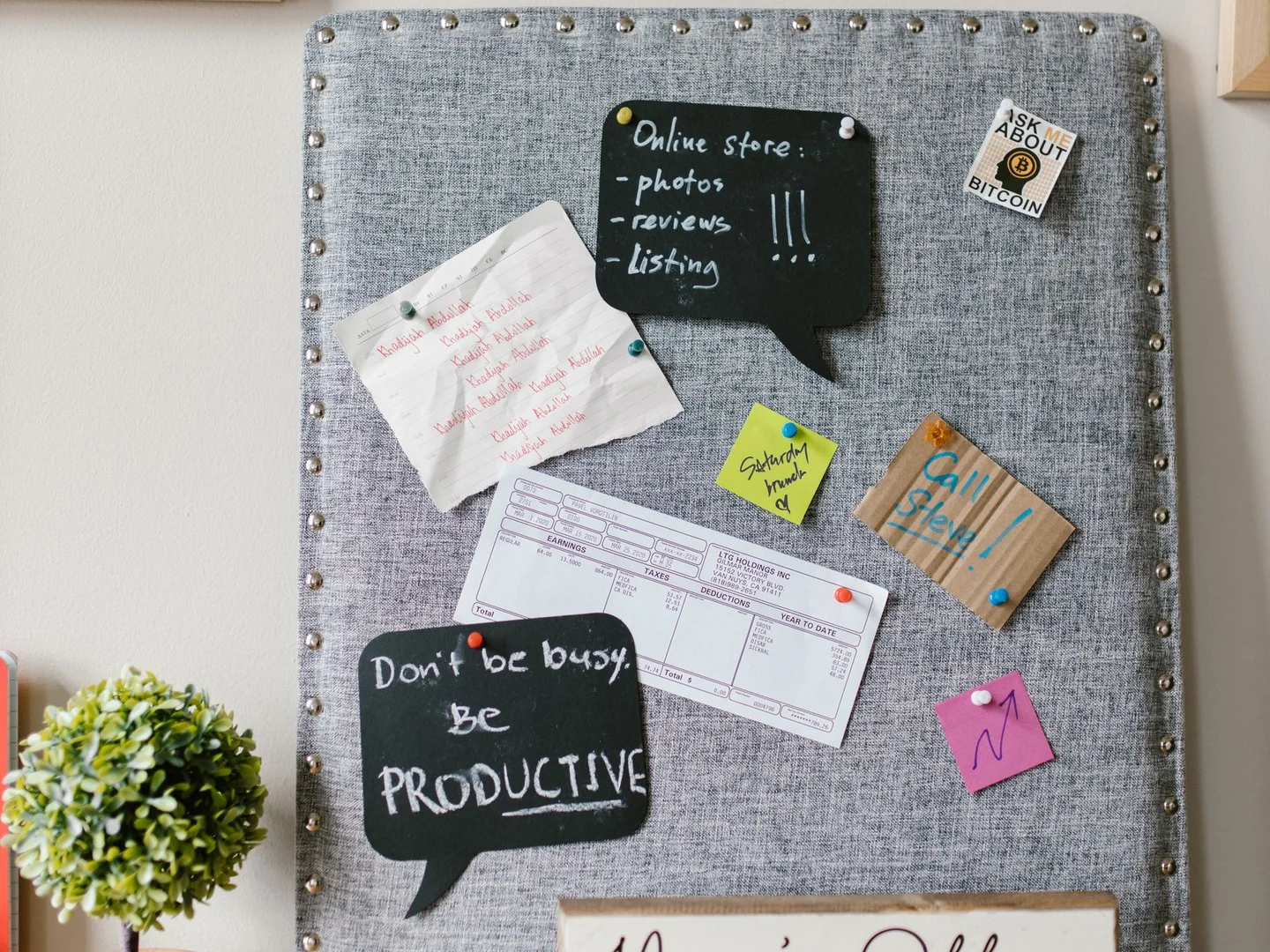 Paper notes clipped to a gray fabric-covered noticeboard.