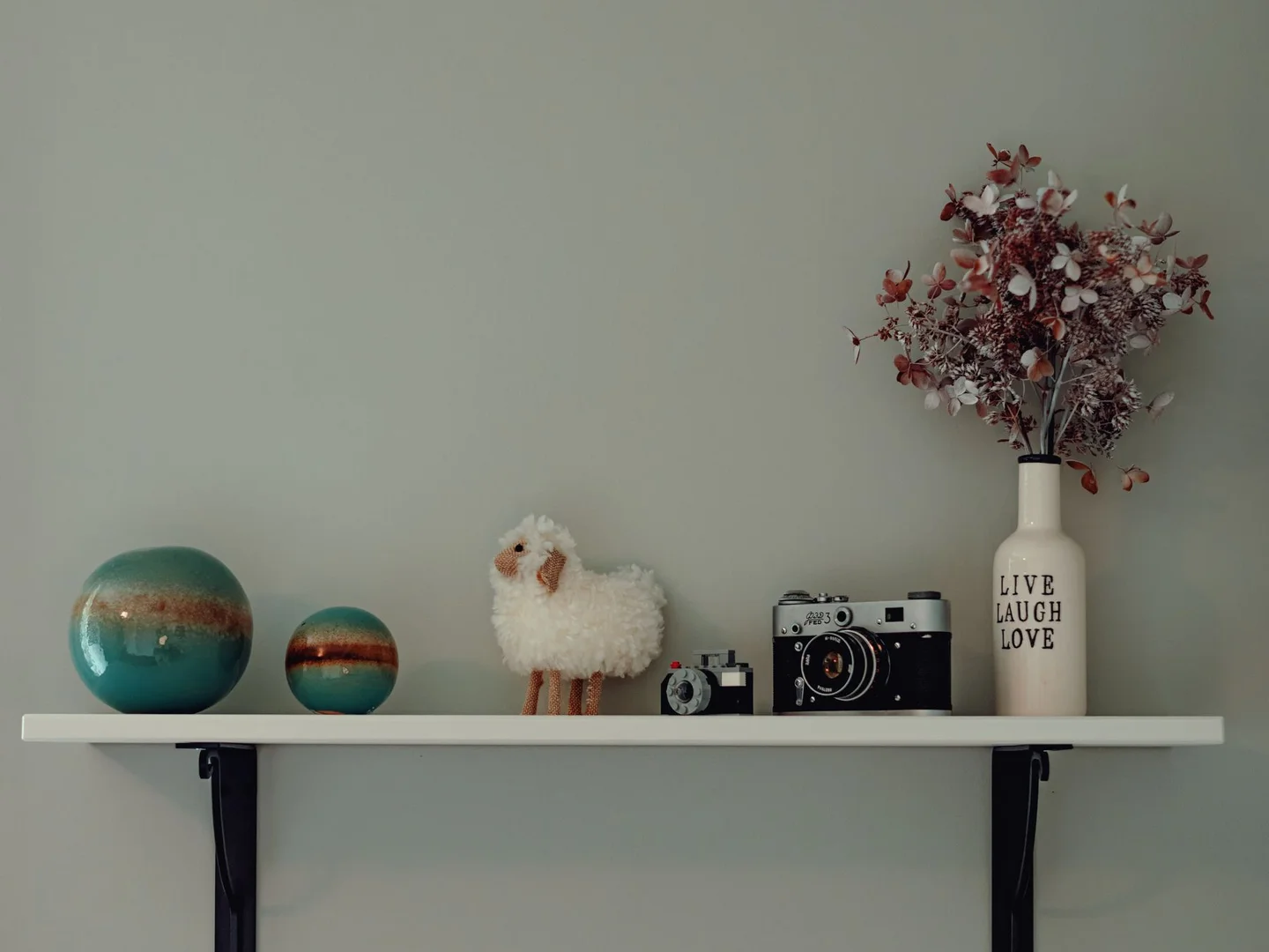 Small decorative objects arranged on a wall shelf.