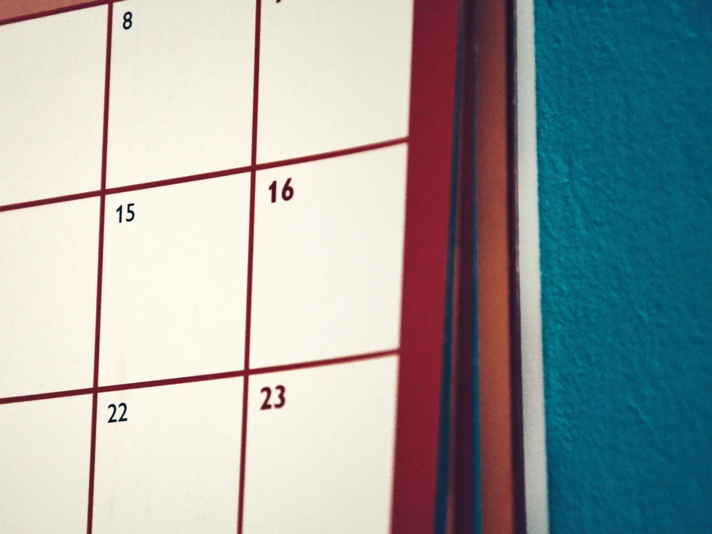 A paper calendar hanging on a wall.