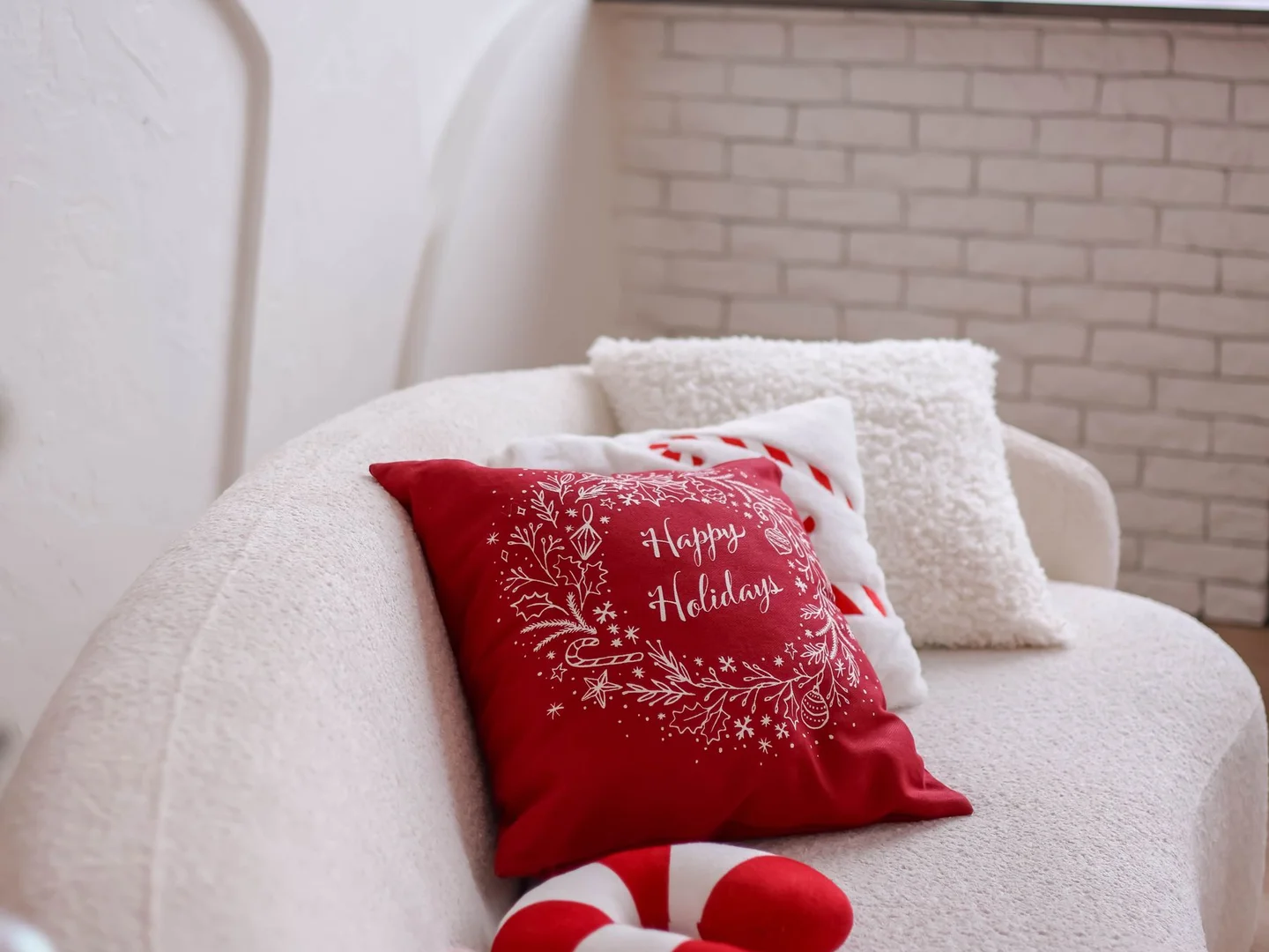 Holiday-patterned cushions arranged on a white sofa.