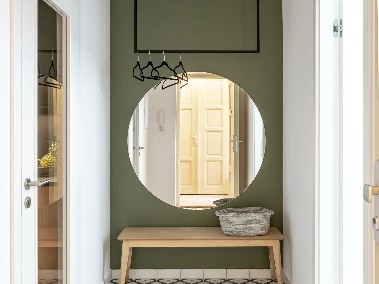 A large round mirror above a hallway console.