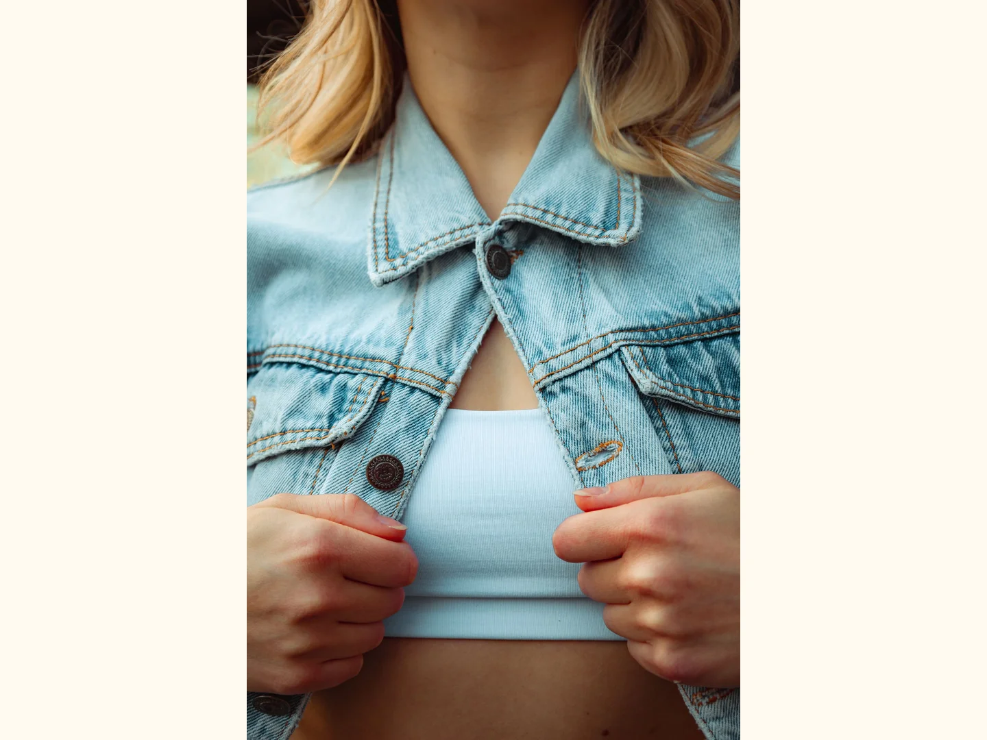 A blue denim jacket worn over a white top.