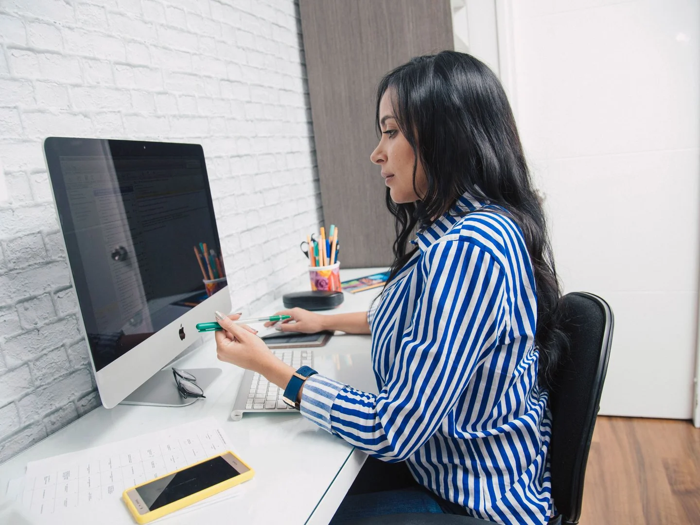 A striped shirt worn with a casual outfit at a desk.