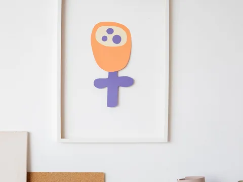 A child's colorful paper artwork displayed inside a picture frame.