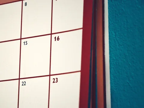 A paper calendar hanging on a wall.