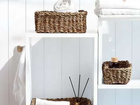 Woven baskets arranged on bathroom shelves.