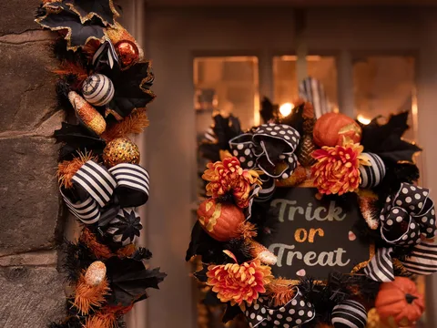 A front door decorated with a Halloween wreath.