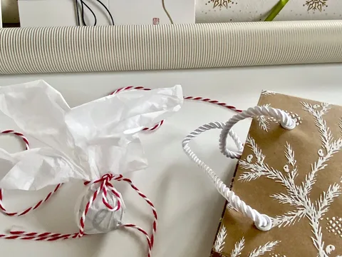 Paper gift bags decorated with fabric ribbons.