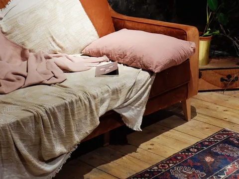 Soft blankets draped over a sofa with cushions.