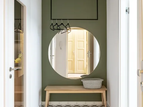 A large round mirror above a hallway console.