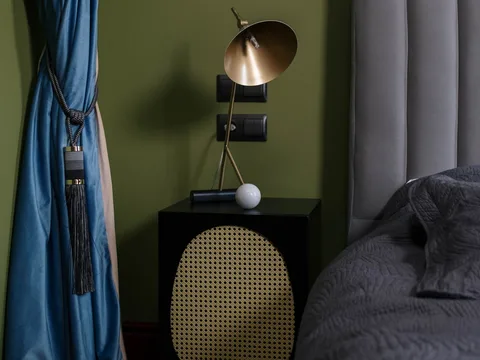 A shaded table lamp on a bedside table.
