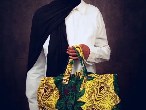 A patterned handbag carried with an outfit.