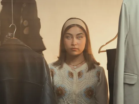 A shopper looking through clothes in a vintage store.