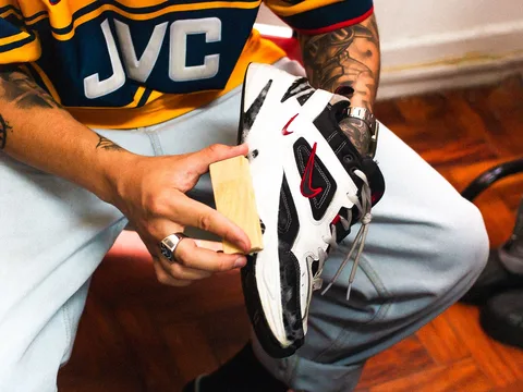 A white sneaker being cleaned by hand.
